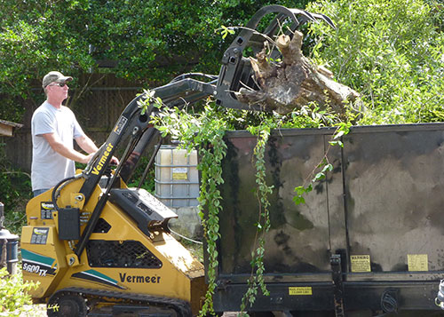 Tom uses the Vermeer mini loader to lift tree debris